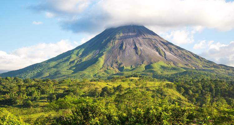 Vue spectaculaire du volcan Arenal s'élevant au-dessus de la luxuriante forêt tropicale avec son chapeau de nuages