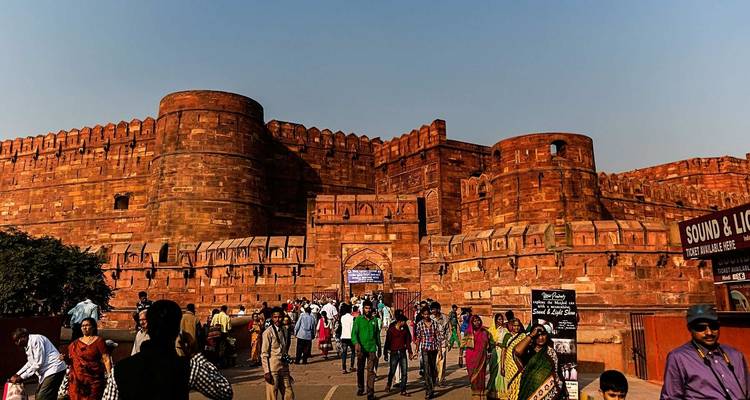 Des gens devant le Fort d'Agra par une journée ensoleillée.