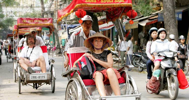 Promenade en cyclo-pousse avec des touristes dans les rues animées de la ville.