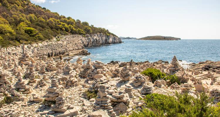 Paysage côtier rocheux avec des centaines de cairns en pierre empilés à côté de la mer