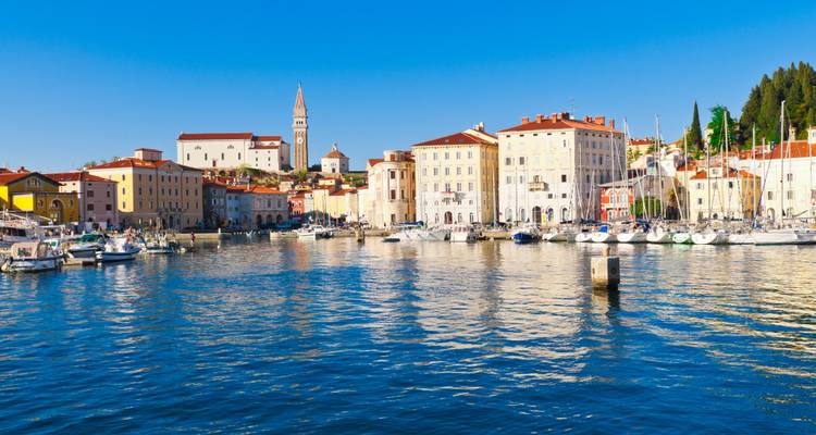 Waterfront coloré de Piran avec des yachts reflétés dans les eaux calmes de l'Adriatique