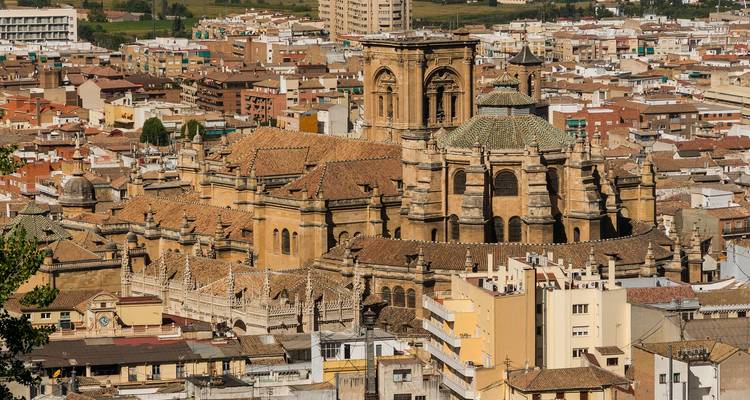 Vue aérienne d'une grande cathédrale entourée de bâtiments urbains.
