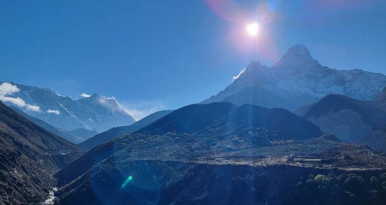 Montagnes avec le soleil qui brille au-dessus d'elles.