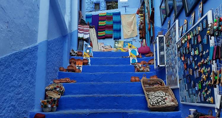 Blau gestrichene Treppen mit ausgestelltem Kunsthandwerk.