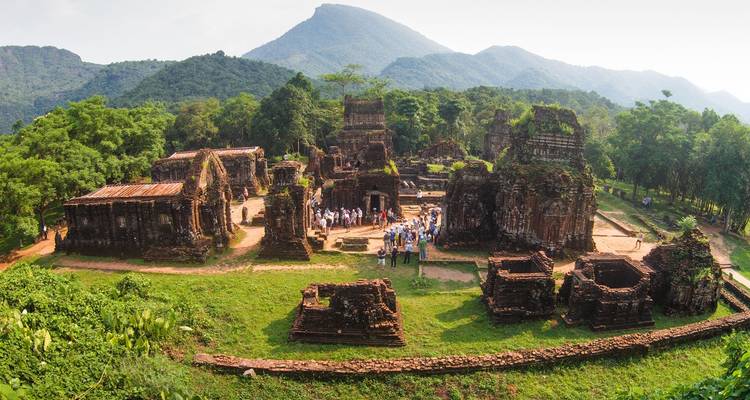 Grupo explorando ruinas históricas en un paisaje exuberante.