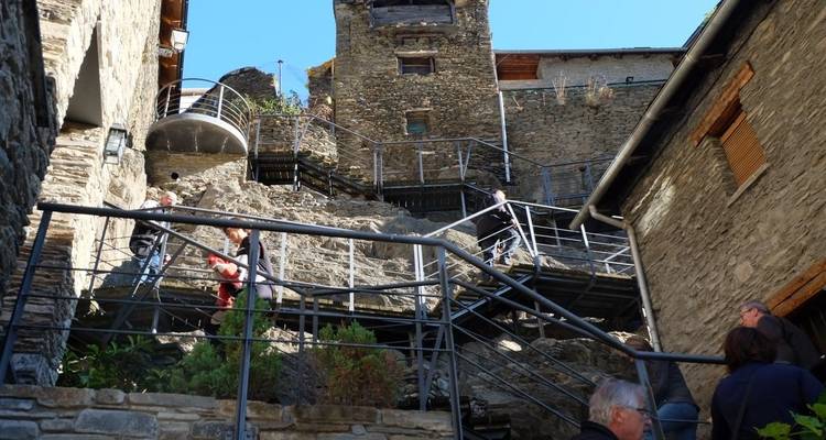 Menschen, die Treppen in einem historischen Steindorf hinaufsteigen.