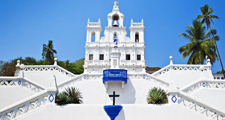 Une église blanche avec des accents bleus sous un ciel dégagé.