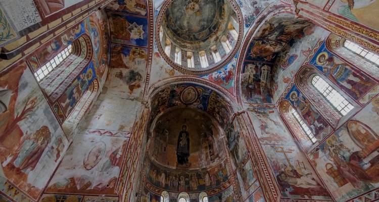 El interior de una catedral con frescos detallados y techos altos.