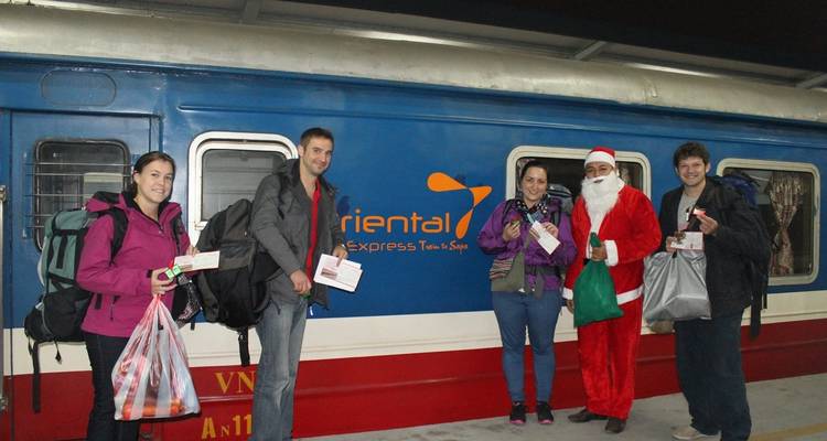 Grupo de personas paradas junto a un tren etiquetado como 'Oriental Express'.
