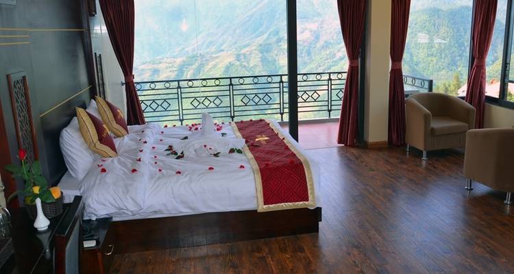 Habitación de hotel de lujo con una ventana grande con vista a las montañas.