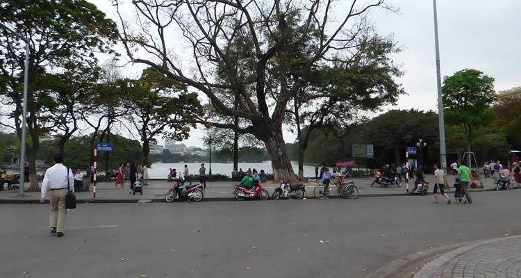 Een voetgangersgebied bij een meer met mensen en motorfietsen.