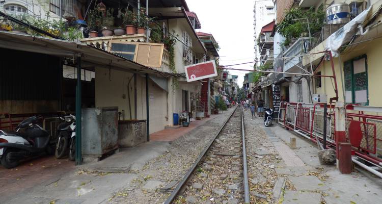Spoorweg die door een smalle woonwijk loopt.