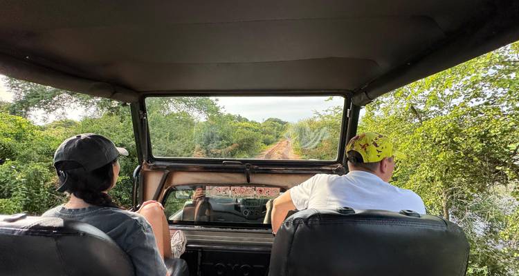 Twee mensen in een voertuig op een landelijke weg.