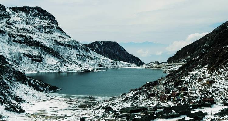 Schneebedeckte Berge, die einen See umgeben.