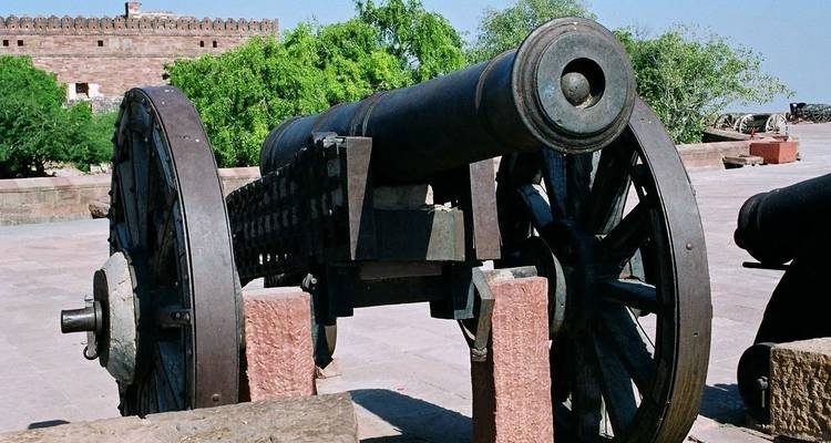 Un canon historique exposé sur le mur d'une forteresse.
