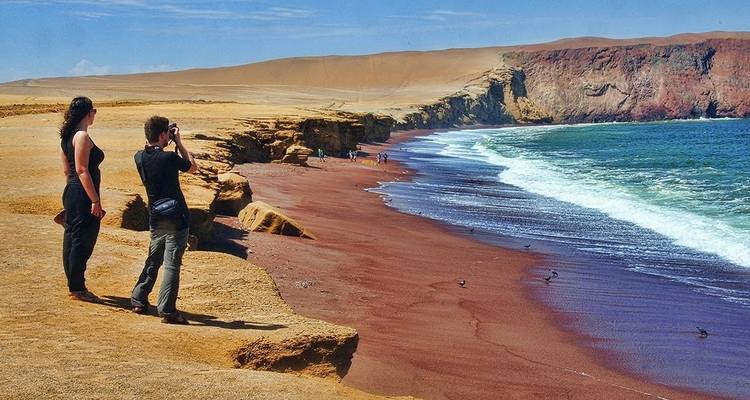 Touristen, die auf einer Klippe mit Blick auf das Meer Fotos machen.