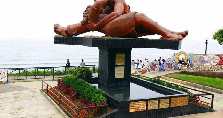 Statue von zwei sich umarmenden Personen mit dem Ozean im Hintergrund.