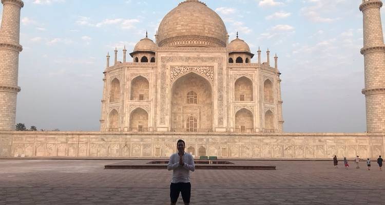 Person, die vor dem Taj Mahal bei Sonnenaufgang posiert.