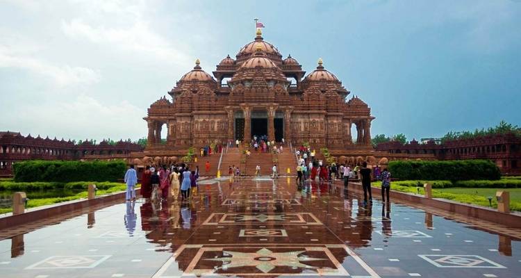 Touristen besuchen einen Tempel mit detailreicher Architektur, wahrscheinlich in Neu-Delhi.