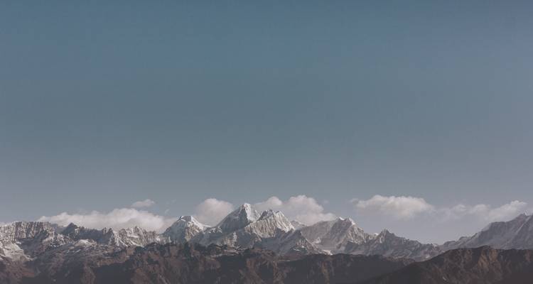 Sommets de montagnes enneigés avec un ciel bleu dégagé.