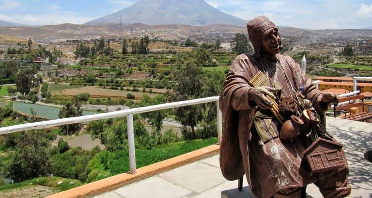 Statue surplombant un paysage pittoresque avec des montagnes.
