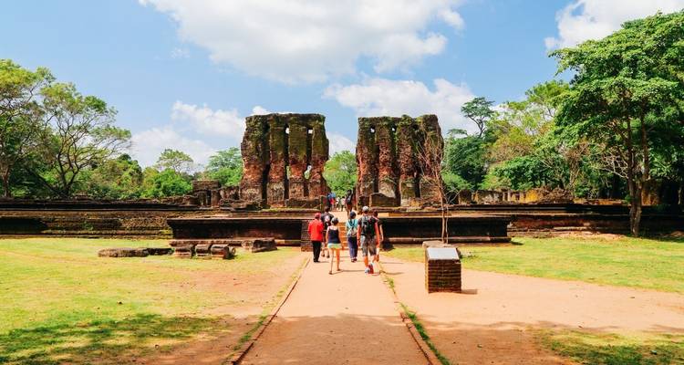 Besucher, die zu antiken Ruinen mit Säulen gehen.