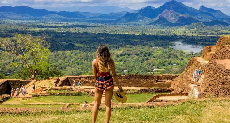 Malerische Aussicht von einem hochgelegenen Punkt mit einer Frau, die auf die Landschaft blickt.