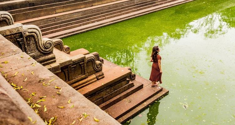Eine Person, die am Rand eines stufenförmigen Beckens steht.