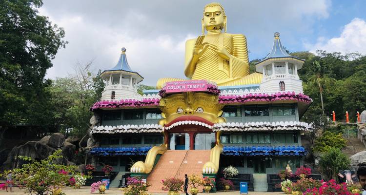 Goldene Buddha-Statue am Eingang einer Tempelanlage.
