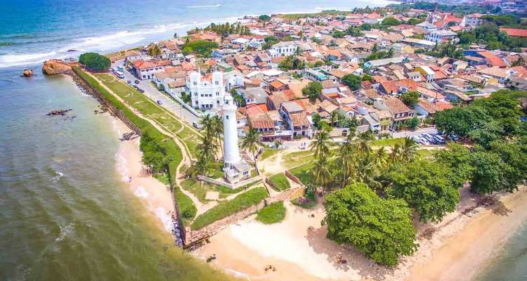 Luftaufnahme von Leuchtturm und Küstenstadt.