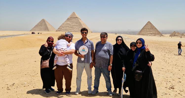 Grand groupe sur un site de pyramide avec un ciel dégagé.