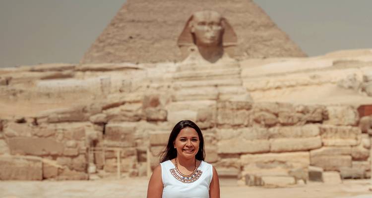 Femme posant avec la Pyramide et le Sphinx en arrière-plan.