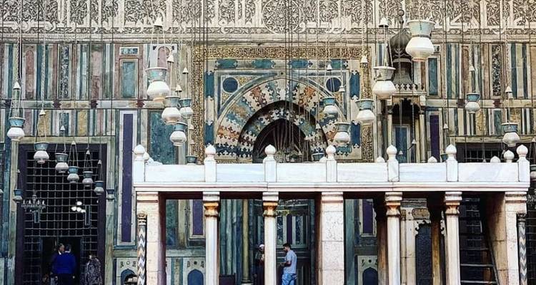 Prachtig versierde oude islamitische architectuur met mensen erin.