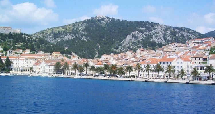 Harbor view with mountains and traditional Croatian buildings.