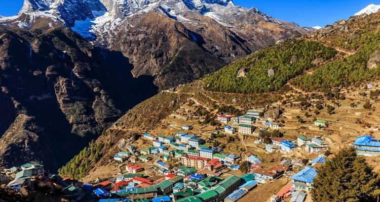 Vue aérienne de Namche Bazar avec ses bâtiments colorés et les montagnes environnantes.