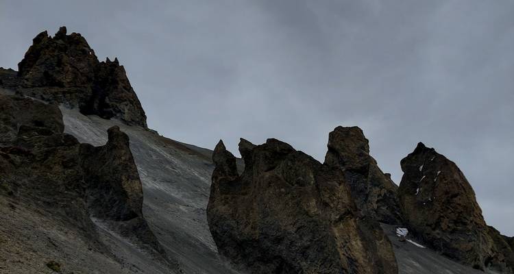 Pics rocheux de montagne contre un ciel nuageux.