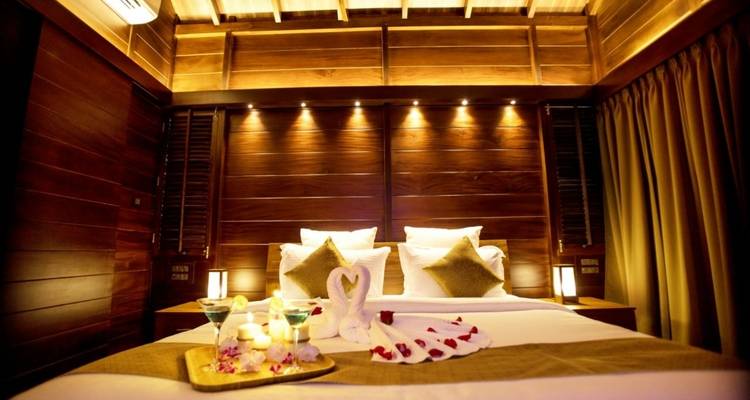 Gemütliches Schlafzimmer mit dekorativer Beleuchtung und Blumenarrangement.