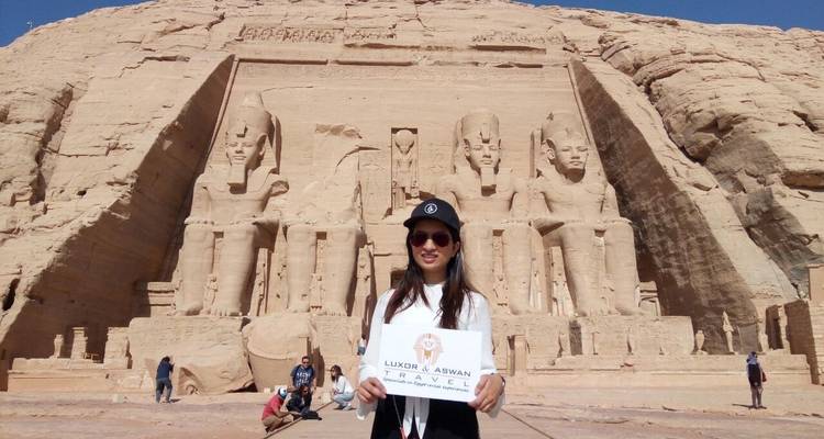 Eine Frau, die ein Schild vor dem Abu-Simbel-Tempel hält.