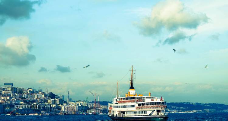Fahrgastfähre, die auf dem Bosporus fährt, mit der Skyline von Istanbul im Hintergrund an einem klaren Tag.