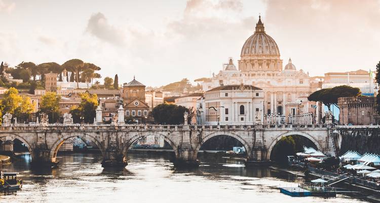 La Basilique Saint-Pierre illuminée au-dessus du Tibre et du Pont Sant'Angelo au crépuscule à Rome.