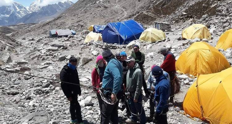 Groep klimmers met tenten in een rotsachtig gebied.