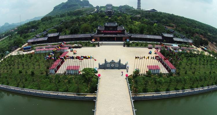 Large traditional building complex with flags and entrance pathway.