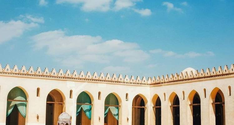 Äußeres eines Gebäudes mit gewölbten Fenstern und kunstvollen Verzierungen.