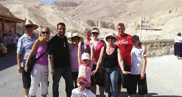 Photo de groupe de touristes sur un site archéologique dans le désert.