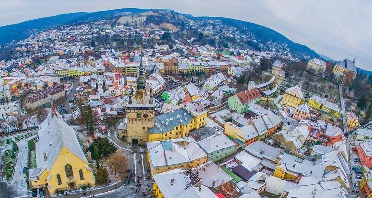 Vue aérienne d'une ville enneigée avec des bâtiments colorés.