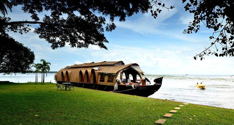 Houseboat moored by a grassy riverside.