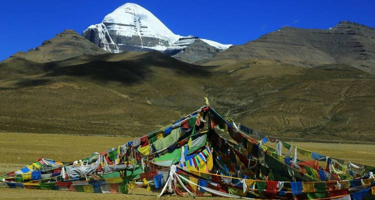 Mountain with multicolored prayer flags in the foreground.
