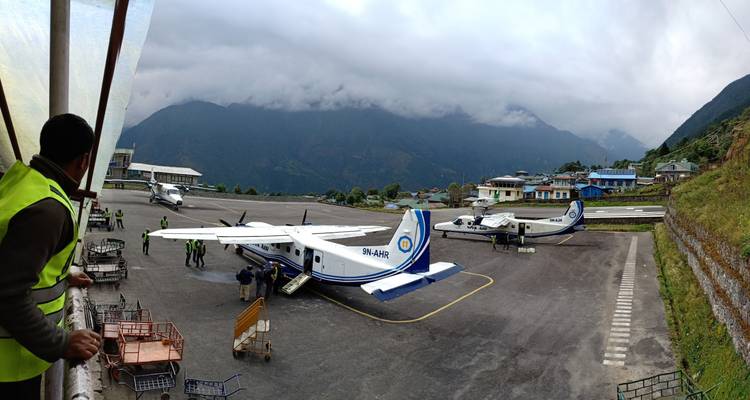 Tarmac d'aéroport avec des avions et des personnes qui embarquent.