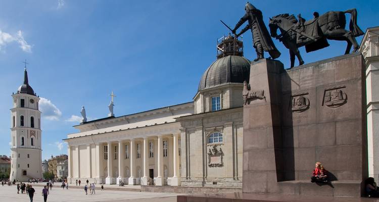 A capital square with a large equestrian statue and historic buildings.