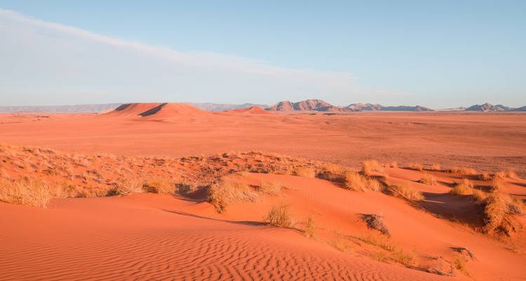Uitgestrekt woestijnlandschap met verre duinen.